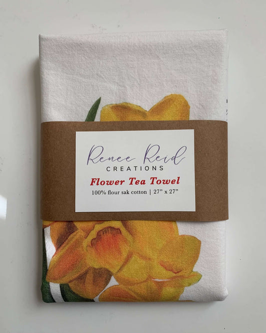 Daffodil Floral Cotton Tea Towel showcasing bright floral artwork in golden hues, perfect for kitchen decor.
