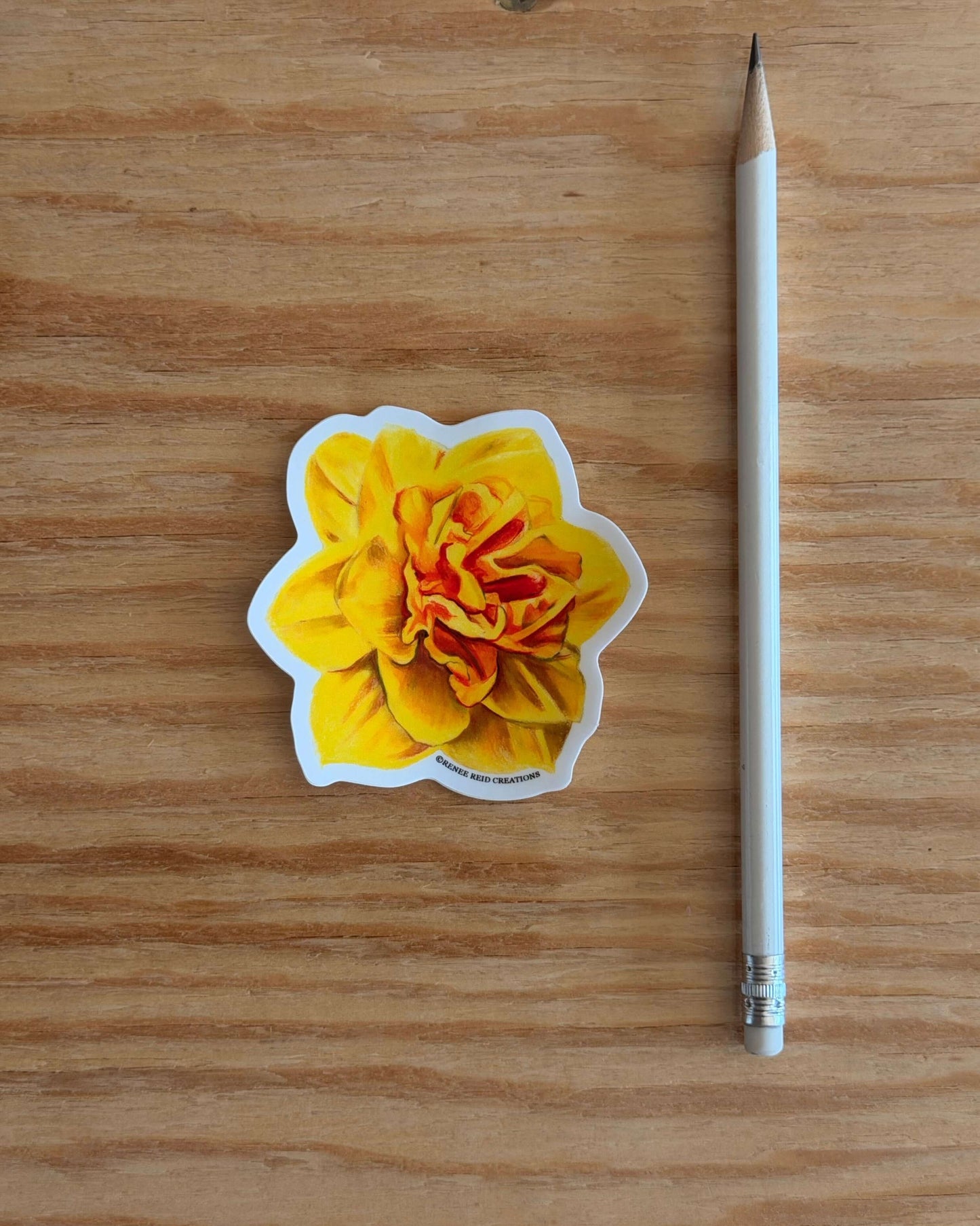 Yellow Daffodil Flower Vinyl Sticker on a wooden surface with a pencil next to it