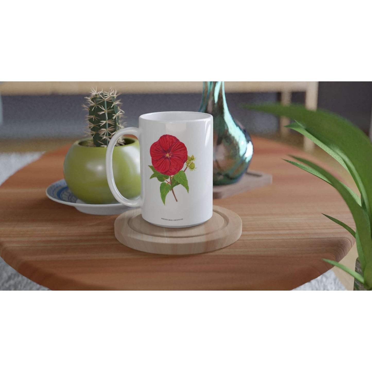 Red Hibiscus Flower Mug 15oz displayed on a wooden table among plants and decor.