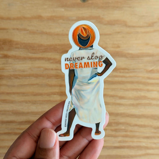 Beyond the Horizon Vinyl Sticker with 'never stop DREAMING' text on a wooden surface.