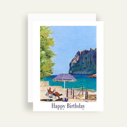 Close up of greeting card with generic text and art of a man sitting by the beach under an umbrella reading the newspaper