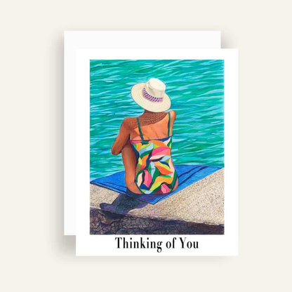 Close up of greeting card with generic text and art of a woman in a colorful swimsuit daydream on a seaside landing