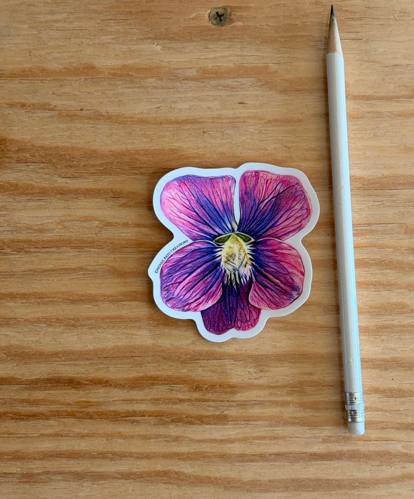 Purple Violet Flower Vinyl Sticker on wooden surface next to a pencil, showcasing vibrant colors and intricate details.