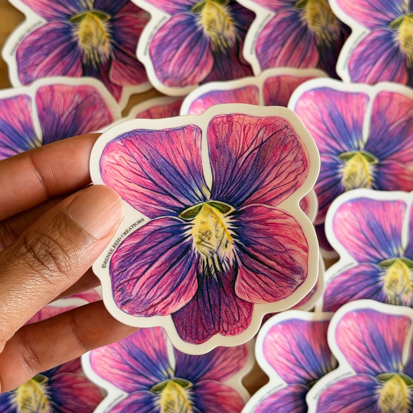 Purple Violet Flower Vinyl Sticker in hand, showcasing intricate details and vibrant colors of the flower design.