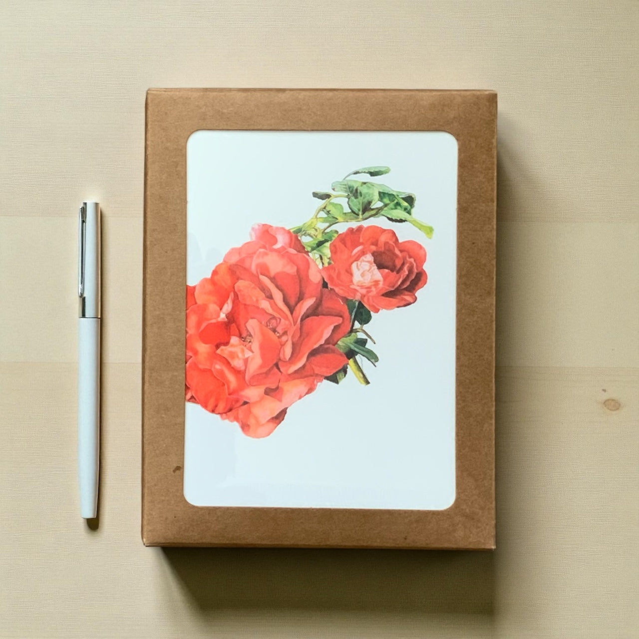Floral Greeting Card Boxed Set with coral roses on the cover and a white pen placed beside it.
