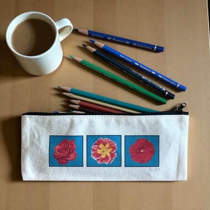 Floral Cotton Canvas Pencil Pouch with floral designs, surrounded by colored pencils and a coffee cup on a wooden table.