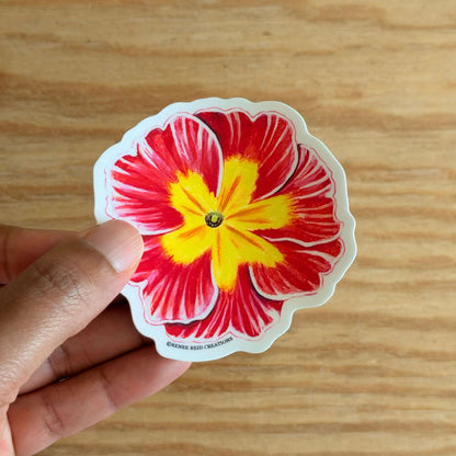 Hand holding a Pink Primrose Flower Vinyl Stickeron a wooden surface