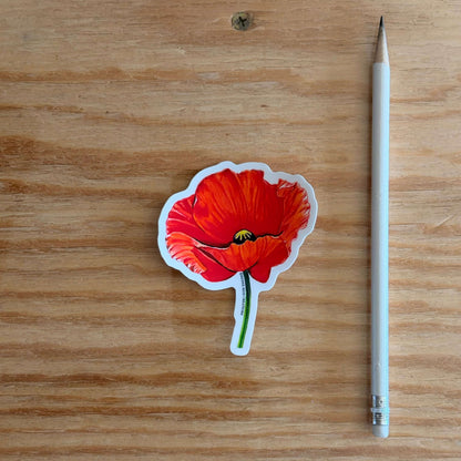 Red Poppy Flower Vinyl Sticker next to a pencil on a wooden surface.