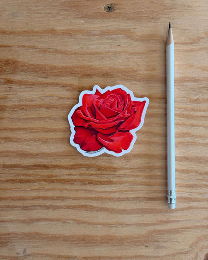 Red Rose Flower Vinyl Sticker and white pencil on a wooden surface