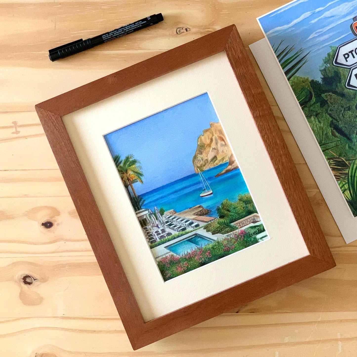 Renee Reid original artwork of a view of an ocean resort with cliffs, beach, boats and palm trees 