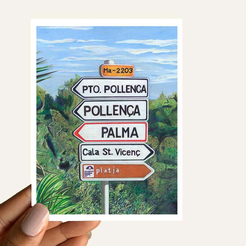 Close up of greeting card of a road sign in Mallorca surrounded by green bushes 